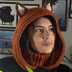 a woman wearing an orange knitted hat with ears