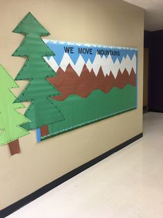 a bulletin board that says we move mountains with trees on the front and back wall