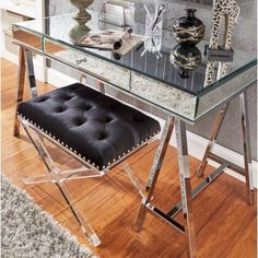 a glass desk with a black chair and giraffe figurines on it