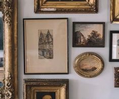 a wall with many framed pictures and paintings on it