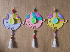 three colorful wooden ornaments hanging on a wall