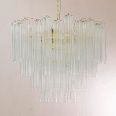 a chandelier made out of glass tubes hanging from the ceiling in a room