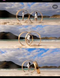 two people are standing on the beach with their wedding rings in front of them and one person is holding a camera