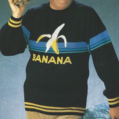 a man in a black sweater holding a banana