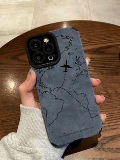 a person holding up a phone case with a map on the back and a cross drawn on it