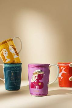 three coffee mugs with different designs on them