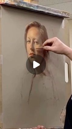 a person is painting a portrait on a canvas