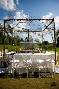 an outdoor wedding setup with white chairs and tables set up for the guests to eat