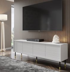 a large flat screen tv mounted to the side of a white entertainment center in a living room