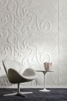 a chair and table in front of a wall with white embossings on it