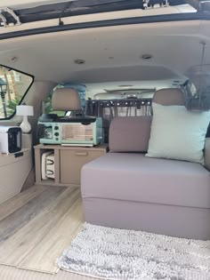 the inside of a van with couches and pillows