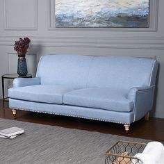 a blue couch sitting on top of a wooden floor