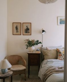 a bed room with a neatly made bed and two pictures on the wall above it