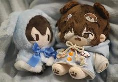 two stuffed animals sitting on top of a blanket