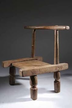 an old wooden chair sitting on top of a white floor next to a gray wall