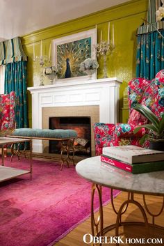 a living room with green walls, pink carpet and colorful furniture in front of a fire place