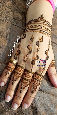 a woman's hand with henna tattoos on it