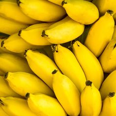 bunches of yellow bananas are stacked on top of each other in this close up photo