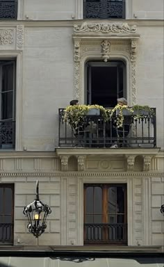 an apartment building with two balconies and flowers on the balcony above it's windows