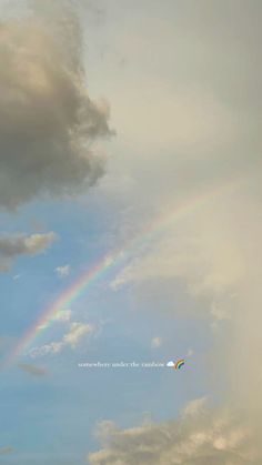 there is a rainbow in the sky with clouds