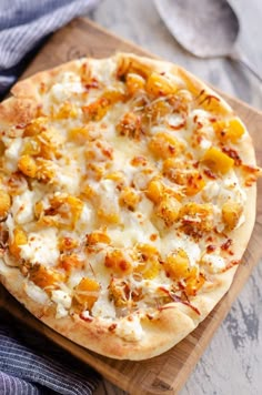 a pizza sitting on top of a wooden cutting board