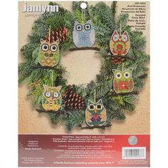 the front cover of an ornament book with owls and pine cones on it