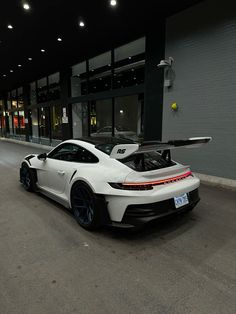 a white sports car parked in front of a building