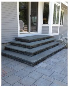 a set of steps leading up to the front door of a house with glass doors