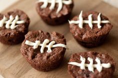 chocolate football cookies with white frosting on a cutting board