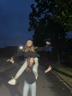 two girls are posing for the camera while one girl is on her back and another girl has her arms in the air