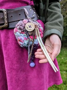 a close up of a person holding two pencils in their hands with buttons on them