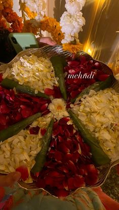 a platter filled with lots of food on top of a table next to flowers