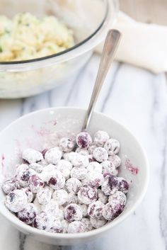 a white bowl filled with blueberries next to a bowl of macaroni and cheese