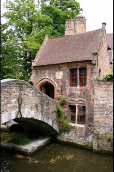 an old brick building with a stone bridge over it