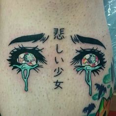 a woman's stomach with an eye tattoo on her side and the words written in japanese characters