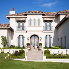 a large white house with lots of windows and steps leading up to the front door