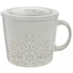 a white coffee cup with a lid on the inside and an intricate design in the outside