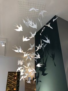 white paper birds are suspended from the ceiling