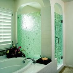 a bath tub sitting next to a walk in shower