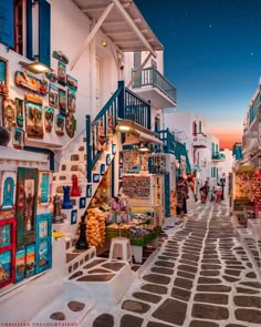 an alley way with shops and people walking down it at dusk in the city center