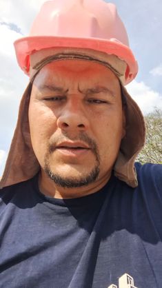 a man wearing a hard hat with his eyes closed