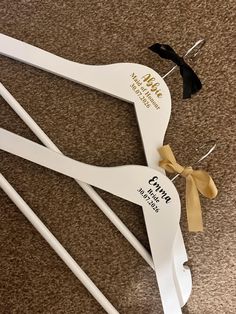 a pair of white scissors with black and gold ribbon tied around them on the floor