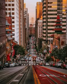 a city street filled with lots of traffic next to tall buildings on either side of the road