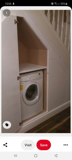 a white washer sitting inside of a dryer next to a stair case in a room