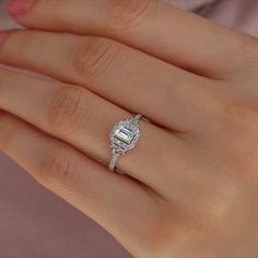 a woman's hand with a diamond ring on top of her finger and an engagement band