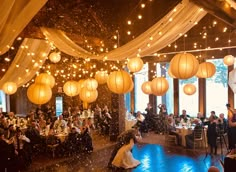 a wedding reception with paper lanterns hanging from the ceiling