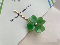 a four leaf clover brooch sitting on top of a piece of paper