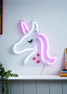 a neon sign with a unicorn's head and stars in the middle on a shelf