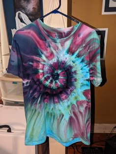 a tie dye shirt hanging on a clothes rack