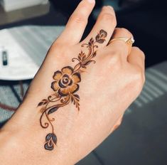 a woman's hand with a flower tattoo on it